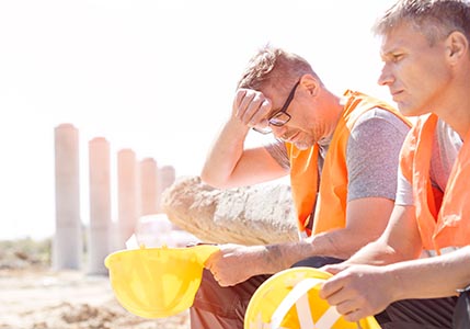 Construction workers outdoors in the summer heat.